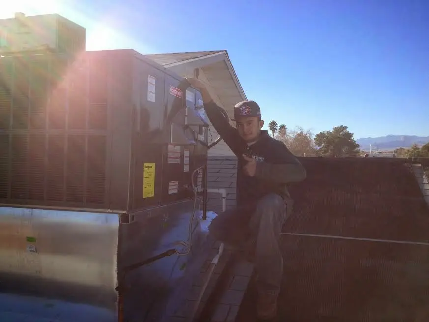 HVAC technician performing HVAC Inspection on a rooftop unit in Braintree Town